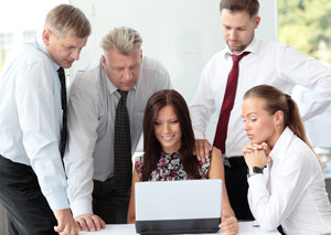 Büro Team vor dem Computer blickt auf Webseite